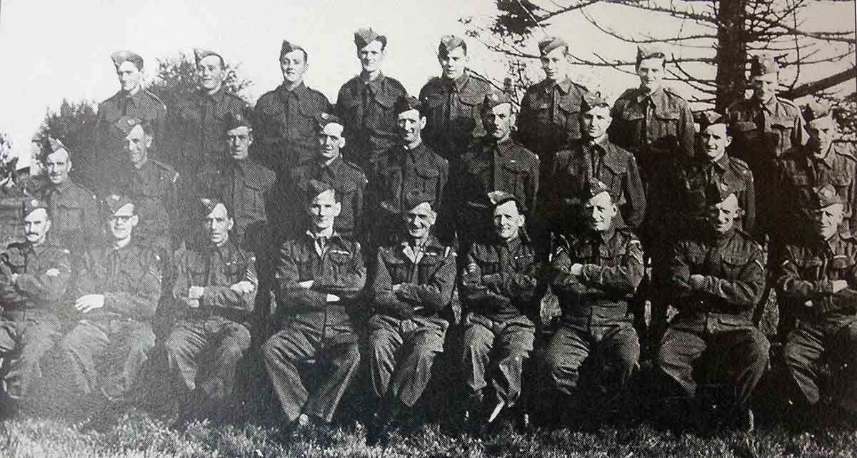 Back row ?, Ronald Prout, Ken Prout, ?, Stan Jones, ?, ?, ?, Middle row Alan Jenkin, Horace Gillbard, Farmer Harris,?, ?,?, Douglas Frayne, Albert Pyke, Albert Cross. Front row Stan Reed, Bob Moffatt, ?, Willis, Harry Gould, Titball, John Grylls, Arthur Francis, Percy Wren. The stores for the Homeguard were situated in a nissen hut at the end of the top lane at Hole Barton.