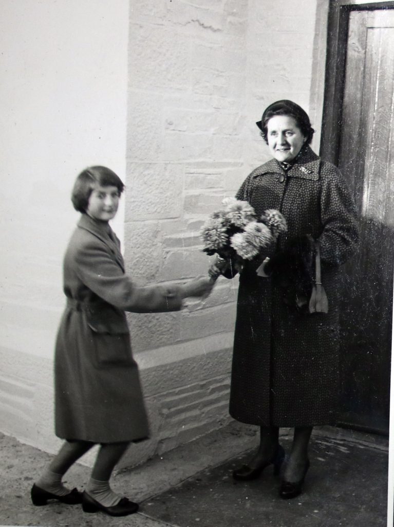 Gwendoline Robins is presented with a bouquet at the 1955 reopening of Laneast Chapel