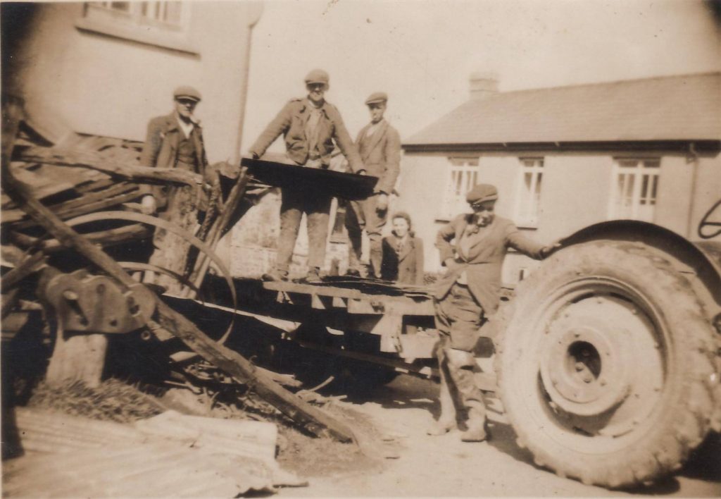 Clearing up W. Lakeman's Blacksmithy after its collapse Bill Tippett (by tractor) Walter Hicks & Bill & Frank Wickett. Photo courtesy of Gary Lashbrook.